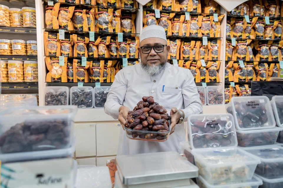 Pengasas dan pengerusi Al Barakah Beauty and Health Mart, Encik A Rahman Bahurudeen bersama pelbagai jenis kurma yang dijual di kedainya di Joo Chiat Road.