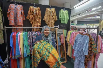 REKAAN 'SIMPLE': Cik Shuhadah Suradi berkata jenama Tuhfah menampilkan rekaan pakaian yang 'simple' dan berangin dengan corak fabrik berwarna-warni bagi koleksi Hari Raya tahun ini. - Foto BH oleh IQBAL FAIIZAL