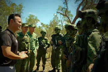 TIMBA PENGALAMAN: Menteri Negara Kanan (Pertahanan merangkap Tenaga Manusia) Encik Zaqy Mohamad (kiri) berinteraksi dengan pasukan Strike ObserveRs Mission1 (Storm) SAF, dan anggota dari Batalion Kedua Rejimen Infantri Singapura (2SIR) yang menyertai latihan.