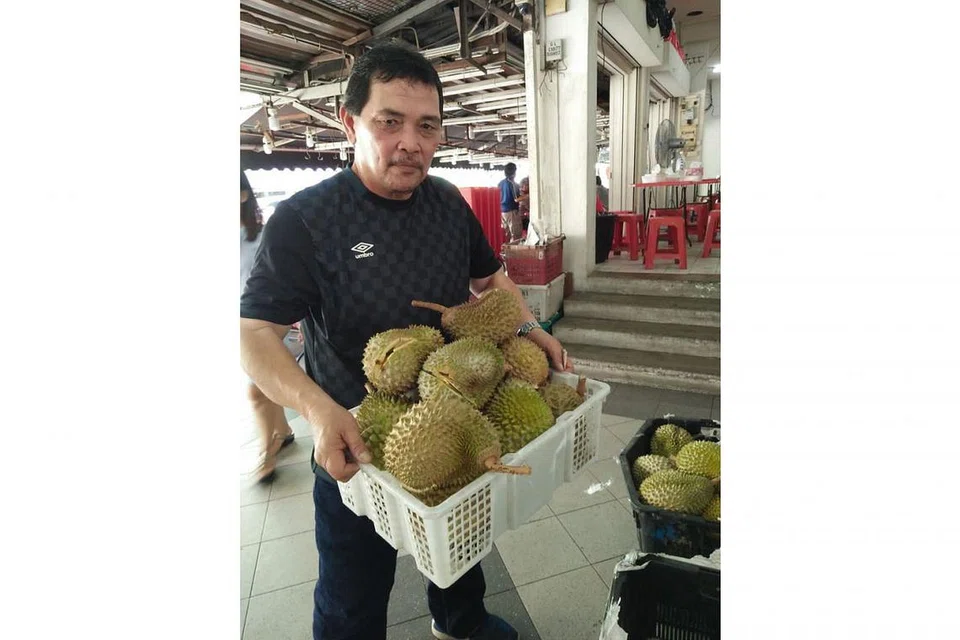 SEDAP, BAIK DAN TIDAK TERKIRA NIKMATNYA: Sekumpulan pekerja Melayu ini dilihat kemaruk makan durian ihsan rakan sekerjanya, Encik Abdul Malek (atas) sempena sambutan hari jadinya yang ke-55 di sebuah gerai di Sims Avenue. - Foto BH oleh SAINI SALLEH