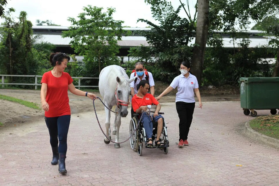 Sukarelawan SRC bersama seorang kurang upaya di Kelab Polo Singapura semasa acara Rumah Palang Merah bagi yang Kurang Upaya (RCHD). Dengan pasukan karyawan kejururawatan, pakar terapi, pembantu penjagaan kesihatan dan ahli fisioterapi serta jurupulih pekerjaan dan pertuturan yang berdedikasi, RCHD menyediakan penjagaan bermutu kepada mereka yang tidak dapat menjaga diri sendiri.
