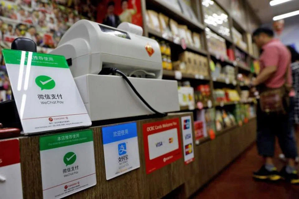 BAKAL DITERIMA DI LEBIH BANYAK TEMPAT: Tanda logo WeChat Pay (kiri) di sebuah kedai di Lapangan Terbang Changi. - Foto REUTERS