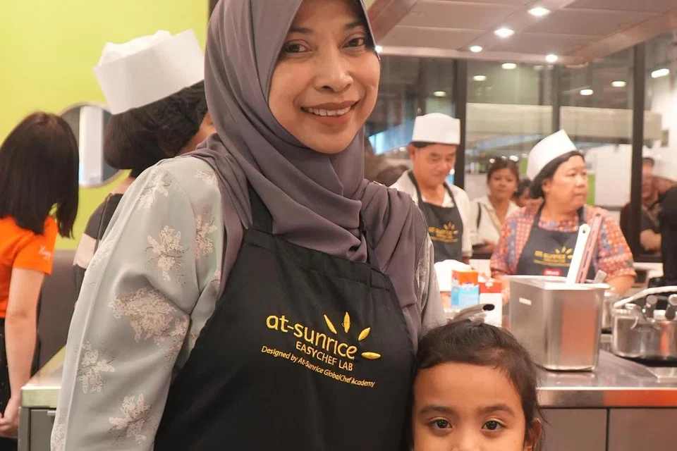 Cik Rosnita Hamid, 55 tahun, bersama cucunya, Auni Zhafirah, lima tahun, menghadiri sesi memasak yang dianjurkan oleh My First Skool di At-Sunrice GlobalChef Academy pada 27 Oktober.