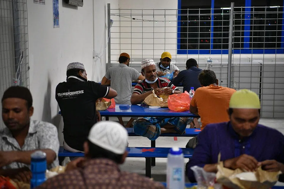 BUKA PUASA: Para pekerja migran duduk bersama untuk berbuka puasa dengan jarak selamat antara satu sama lain. Juadah buka puasa biasanya disediakan majikan mereka, dengan terdapat pihak lain seperti masjid misalnya yang mendermakan bubur juga.