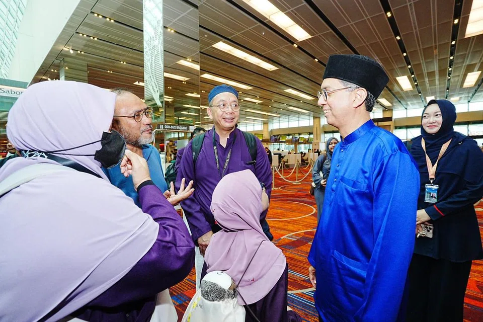 Pemangku Menteri Bertanggungjawab bagi Ehwal Masyarakat Islam, Profesor Madya Dr Muhammad Faishal Ibrahim (dua dari kanan), beramah tamah dengan pasangan suami isteri, Encik Mohammad Dzulkifli Mohyi Hapipi (empat dari kanan) dan isteri, Cik Zhalynda Abdul Rahim (kiri) ketika menghantar jemaah haji Singapura pada 31 Mei. 