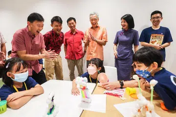 PM Lee Hsien Loong (berdiri, tiga dari kanan) meninjau aktiviti sempena Majlis Ulang Tahun CDAC ke-30 dan Rumah Terbuka Ibu Pejabat 2022. Foto GIN TAY