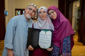 Pemenang Anugerah Madrasah, Cik Zakiyah Hanim Zaini (tengah) bersama ayahnya, Encik Zaini Abas (kiri) dan ibunya, Cik Jaliah Mohd Nor (kanan).
