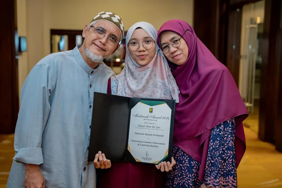Pemenang Anugerah Madrasah, Cik Zakiyah Hanim Zaini (tengah) bersama ayahnya, Encik Zaini Abas (kiri) dan ibunya, Cik Jaliah Mohd Nor (kanan).