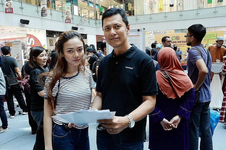 CARI KURSUS PENINGKATAN: Encik Awi Hussain menemani anaknya, Cik Naryah Awi, yang mahu mendapatkan kursus peningkatan. - Foto JOHARI RAHMAT