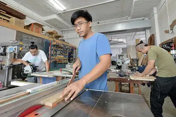 BAKAT MUDA: Encik Chua (depan) berkata industri pertukangan kayu tidak ketandusan bakat muda yang ingin menyumbang daya kreatif mereka. - Foto ZAINAL YAHYA