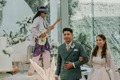 Bapa pengantin perempuan, Shaik Abdul Halim (belakang) memainkan lagu instrumental Young and Beautiful di elektrik gitarnya, permintaan mempelai Cik Diyana Mas Ayu Shaik Abdul Halim (kanan) dan Encik Muhammad Tarmizi Mahat (kiri) semasa majlis perkahwinan mereka pada 1 November di Hotel Furama Riverfront.