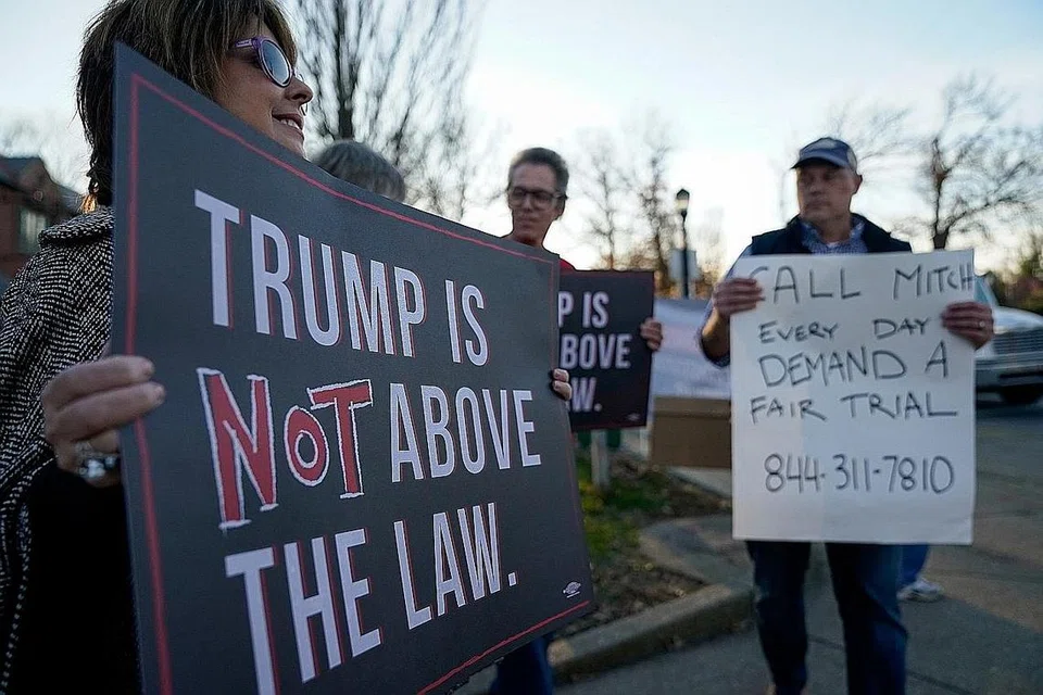 LUAHKAN PERASAAN: Penunjuk perasaan menegaskan bahawa Encik Trump tidak boleh lari daripada undang-undang. - Foto REUTERS