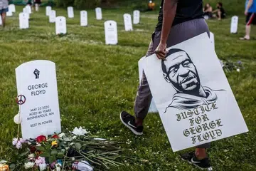 MENGENANG MANGSA KEGANASAN: Seorang warga memegang sepanduk dengan potret George Floyd semasa acara memperingati pemergian mangsa keganasan polis di Minneapolis, Minnesota. Demonstrasi diadakan di seluruh Amerika Syarikat berikutan kematian Encik Floyd, 46 tahun, pada 25 Mei 2020 dalam tahanan polis.