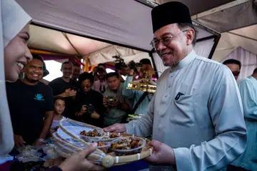Perdana Menteri Malaysia, Datuk Seri Anwar Ibrahim, menyantuni orang ramai yang hadir ke Majlis Sambutan Aidilfitri Madani 2025 Peringkat Perlis di Dataran Lok 9, Kuala Perlis, Perlis, pada 27 April.