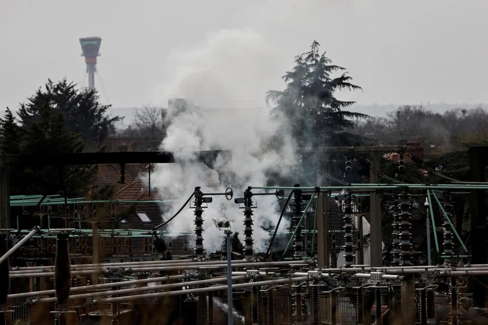 Asap berkepul-kepul kelihatan menjulang dari kawasan pencawang elektrik dengan menara kawalan Lapangan Terbang Antarabangsa Heathrow di latar belakang, selepas kebakaran memusnahkan bekalan elektrik di lapangan terbang tersebut, di Hayes, London, Britain, 21 Mac 2025. 