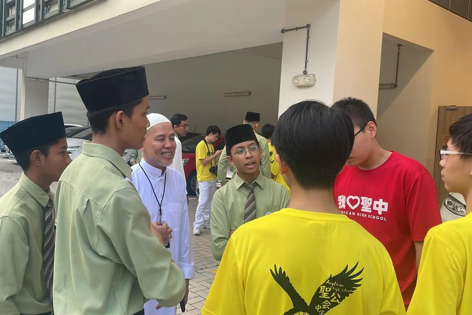Pelajar dan guru MAI berinteraksi dengan pelajar Sekolah Tinggi Anglican (AHS) sebelum acara melawat penerima habuan baucar dan barangan runcit daripada MAI pada April 2023. 