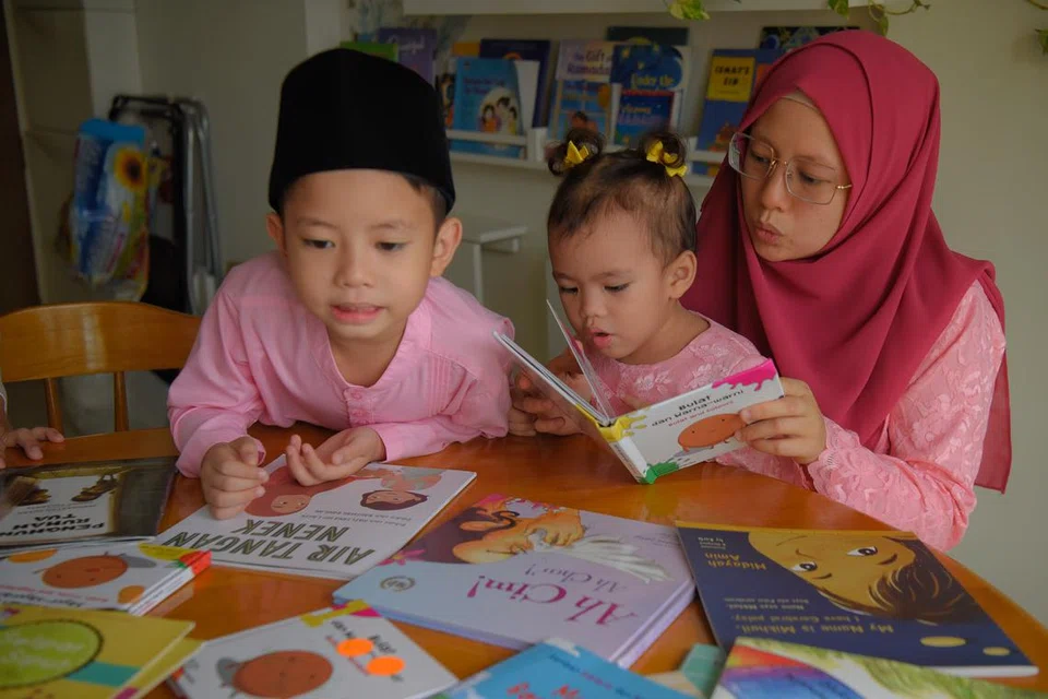 BINA PENGUASAAN BAHASA: Cik Far’ain Jaafar membaca buku Melayu bersama anaknya, Khalief Syafiq dan Nuhyah Syafiq pada 2021.