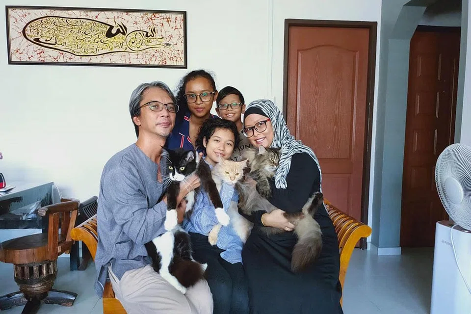 GEMBIRA PERKHIDMATAN DISAMBUNG: Encik Riduan, yang mempunyai tiga kucing peliharaan, tidak membuang masa membuat janji temu bagi khidmat dandanan untuk salah seekor kucingnya, Satria Hitam (dipegang isterinya, Cik Suzana Su'ah). Bulu kucing jenis kacukan Maine Coon, Parsi dan Bengal ini amat sukar dijaga dan perlu dicukur agar ia selesa dalam cuaca yang panas di sini. - Foto ihsan RIDUAN AHLIP