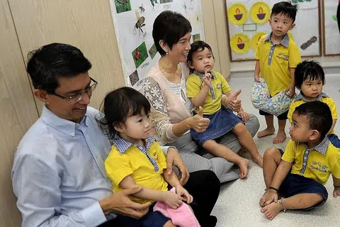 PUSAT PENJAGAAN KANAK-KANAK BARU: Cik Josephine Teo dan Dr Muhammad Faishal Ibrahim berinteraksi dengan kanak-kanak di pusat penjagaan Skool4kidz Tampines GreenLeaf. Pusat penjagaan seluas 580 meter persegi ini mula beroperasi Oktober tahun lepas dan mempunyai seramai 115 kanak-kanak dan 10 bayi di bawah jagaannya. Skool4kidz bakal menyediakan tambahan 380 tempat menerusi pembukaan tiga pusat baru di Yishun, Punggol dan Tampines menjelang suku pertama tahun depan. - Foto THE STRAITS TIMES