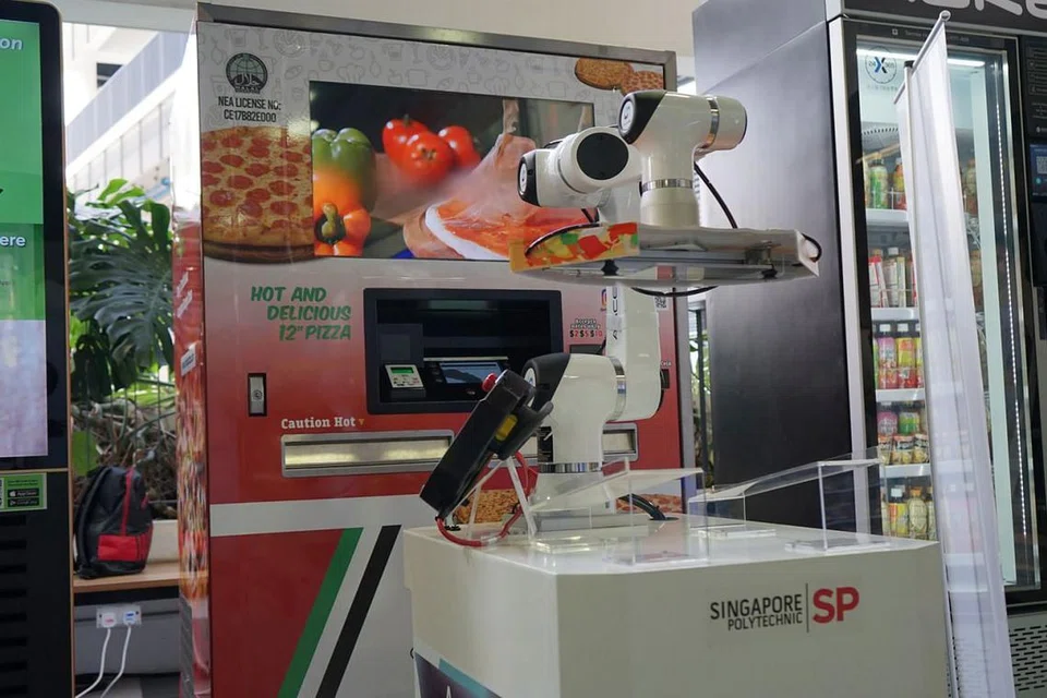 PELBAGAI MESIN MENARIK: Ketua jawatankuasa penganjur pameran perdagangan mesin layan diri di Politeknik Singapura, Cik Nurul Amirah Mohd Jefri, berkata terdapat pelbagai mesin layan diri yang ditampilkan, termasuk mesin piza yang mempunyai robot untuk menghantar piza kepada pelanggan dan mesin yang menggunakan teknologi pengecaman tapak tangan. - Foto SP