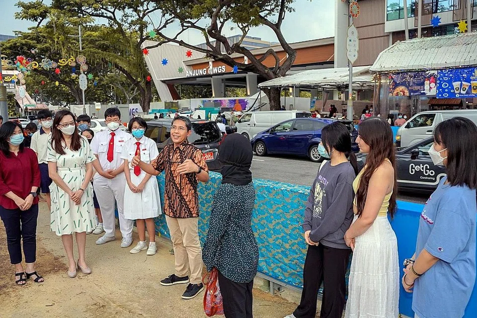 SELAMI SEJARAH MELALUI SENI: Dr Maliki (dua dari kanan) melancarkan paparan seni kanvas awam bertemakan warisan Geylang Serai dari 1950-an hingga ke masa kini di Geylang Road semalam. - Foto-foto BH oleh NUR DIYANA TAHA