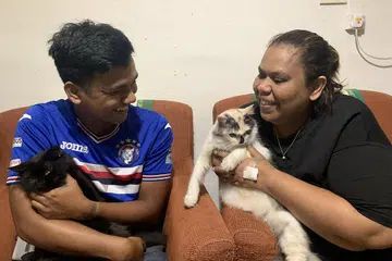 SELAMATKAN KUCING: Cik Faridah dan anaknya, Encik Norrashraf, gembira dua kucing kesayangan mereka selamat semasa flat jirannya terbakar. - Foto BH oleh NUR SYUHRAH HASSAN