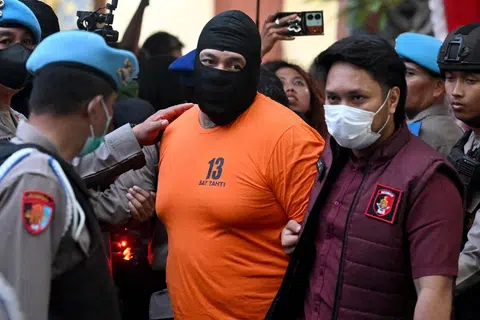 Anggota polis mengiringi suspek warga Australia, Tupou Pasa Midolmore (tengah), ke sidang media di Ibu Pejabat Polis Daerah Badung, Bali pada 26 Jun 2025. Polis Indonesia memaklumkan bahawa tiga warga Australia telah ditahan dan berdepan hukuman mati atas kesalahan membunuh rakan senegara mereka di pulau peranginan Bali, selepas operasi memburu selama beberapa hari.