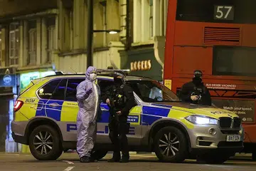 KAWAL LOKASI KEJADIAN: Seorang pegawai forensik bercakap dengan seorang pegawai polis di Streatham High Road, selatan London, selepas seorang lelaki menikam beberapa mangsa. - Foto AFP