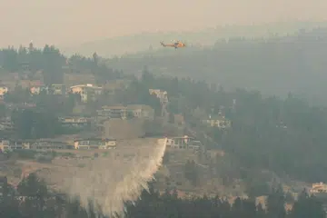 KEADAAN DARURAT: Sebuah helikopter menjatuhkan air ketika kebakaran hutan McDougall Creek terus marak di West Kelowna, British Columbia, pada 19 Ogos. 