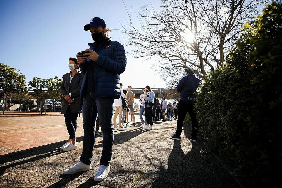 DAPATKAN VAKSIN: Orang ramai sedang beratur di luar pusat vaksinasi Covid-19 di Cape Town, Afrika Selatan, bagi mendapatkan suntikan vaksin. - Foto REUTERS