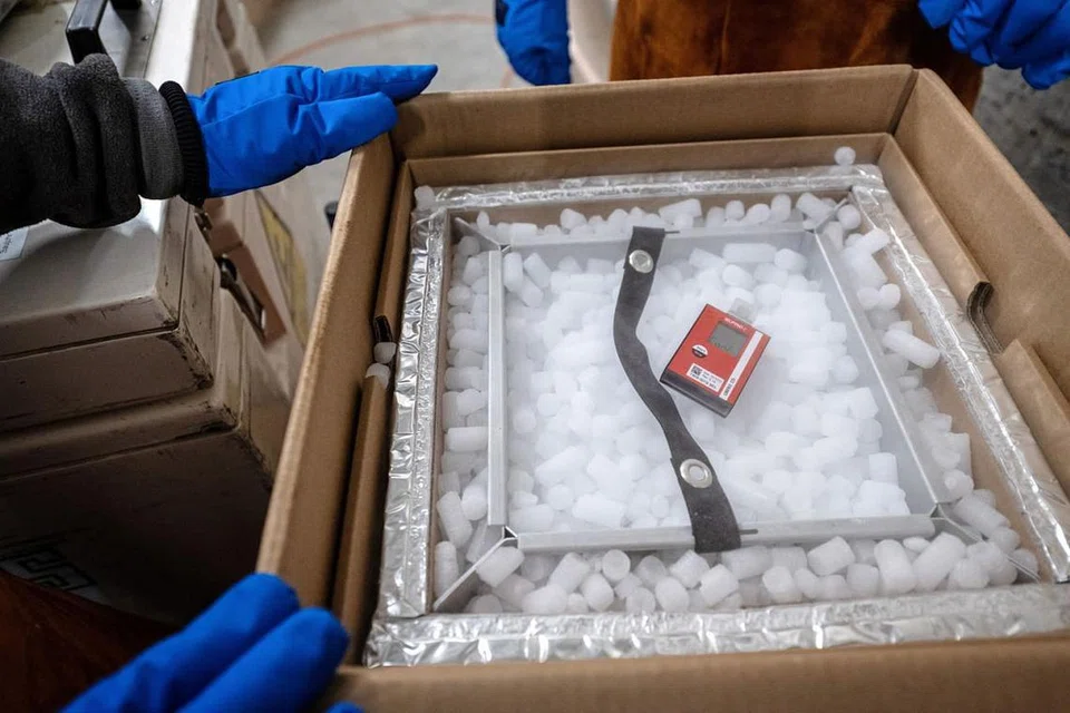 BEKALAN PERTAMA: Sebuah perakam data di atas kotak peti sejuk beku adalah bekalan pertama vaksin Covid-19 Pfizer-BioNTech di sebuah farmasi di Switzerland. - Foto REUTERS 