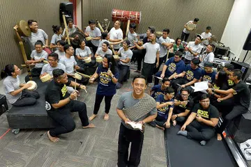PERTUNJUKAN GENDERANG: Anggota Nadi Singapura, Muhammad Zulfadhli Othman (hadapan), memainkan peranan utama, Taufan, yang akan menyerikan lagi pertunjukan 'Journey 2: The Pulse', gabungan kumpulan genderang Melayu Nadi Singapura dengan pelajar ITE Kolej Central dan ITE Kolej Timur. - Foto TUKIMAN WARJI