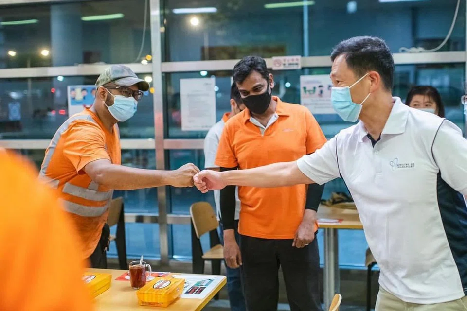 TANDA TERIMA KASIH: Encik Ong Ye Kung (kanan) berjabat tangan dengan pekerja sektor pengangkutan di SBS Transit, memberi mereka galakan dan mengucapkan terima kasih di atas kerja keras yang dilaburkan. - Foto-foto FACEBOOK ONG YE KUNG