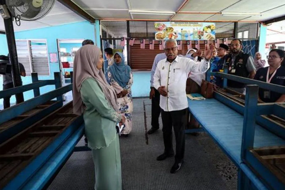 Pengerusi Jawatankuasa Sumber Manusia, Kesihatan, Hal Ehwal Masyarakat India dan Integrasi Nasional Perak, Encik A Sivanesan (kanan), memeriksa tahap kebersihan kantin Sekolah Kebangsaan Chepor di Ipoh, Perak, selepas penggendali kantin sekolah itu ditamatkan kontrak kerana menyebabkan 134 guru dan murid keracunan makanan pada 24 September.