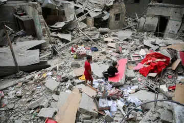 Kanak-kanak Palestin melihat kesan kemusnahan akibat serangan udara Israel ke atas bangunan di Rafah, selatan Gaza, pada 27 April.