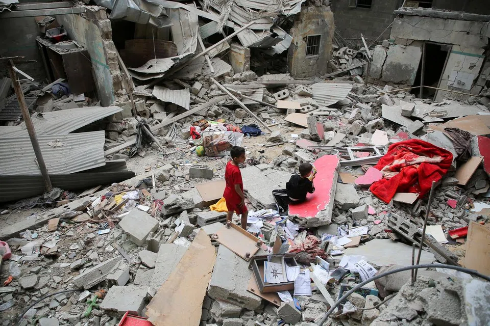 Kanak-kanak Palestin melihat kesan kemusnahan akibat serangan udara Israel ke atas bangunan di Rafah, selatan Gaza, pada 27 April.