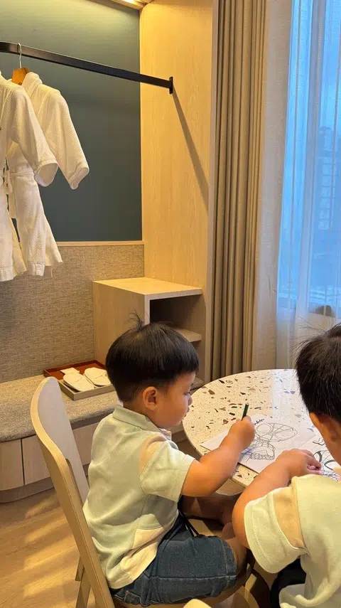Anak-anak penulis melakukan kegiatan mewarna di meja yang tersedia dalam bilik kanak-kanak.