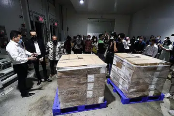 ALTERNATIF BAGI SUMBER AYAM: (dari kiri) Encik Leek, Menteri Negara Kanan (Kemampanan dan Sekitaran merangkap Tenaga Manusia), Dr Koh Poh Koon, dan Encik Suryo, menerima kumpulan ayam beku pertama dari Indonesia yang tiba di Singapura. Ayam beku pertama dari Indonesia - Foto-foto BH oleh KELVIN CHNG
