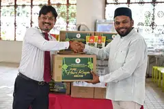 Encik J Balasubramaniam (kiri), anggota kewangan Lembaga Endowmen Hindu, menyampaikan kotak kurma kepada naib pengerusi Masjid Angullia, Encik Abdul Aziz Yusof, di Masjid Angullia pada 26 Mac.