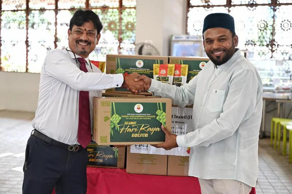 Encik J Balasubramaniam (kiri), anggota kewangan Lembaga Endowmen Hindu, menyampaikan kotak kurma kepada naib pengerusi Masjid Angullia, Encik Abdul Aziz Yusof, di Masjid Angullia pada 26 Mac.