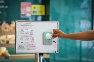 LEBIH MUDAH DAN PANTAS: Untuk daftar masuk ditempat guna Kotak Pintu Masuk SafeEntry, pengunjung boleh menggunakan aplikasi atau token TraceTogether dan menyentuh alat mereka pada kotak pintu masuk, yang saiznya lebih besar sedikit daripada telefon bimbit. - Foto ZAOBAO