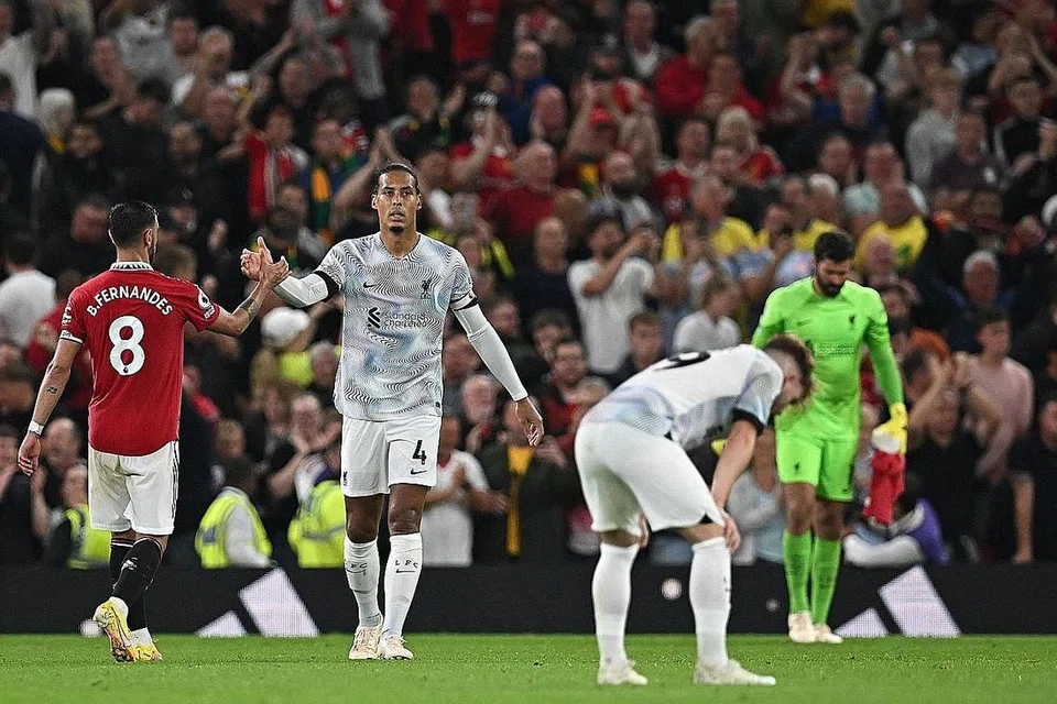 KECEWA: Sedang penyokong United gembira dengan kemenangan pasukan kegemaran mereka, para pemain Liverpool (berjersi putih) bak tidak dapat menahan kekecewaan selepas wisel penamat ditiup pengadil.