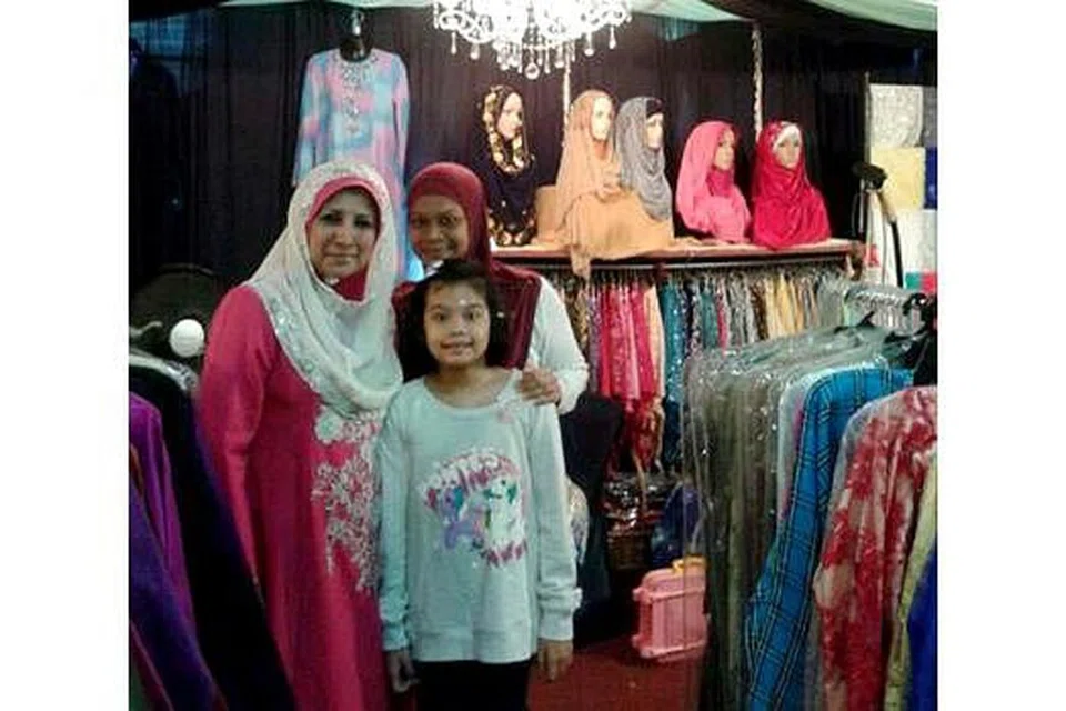 PENJUALAN MENGGALAKKAN: Cik Mona (kiri) bersama pelanggannya yang mengunjungi gerainya di Bazar Raya Utara. - Foto MONA J 