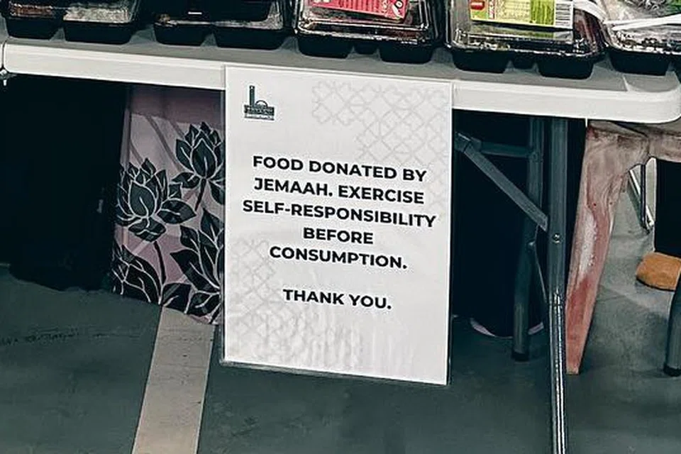 Kakitangan dan relawan masjid mengagihkan makanan di masjid Masjid Maarof.