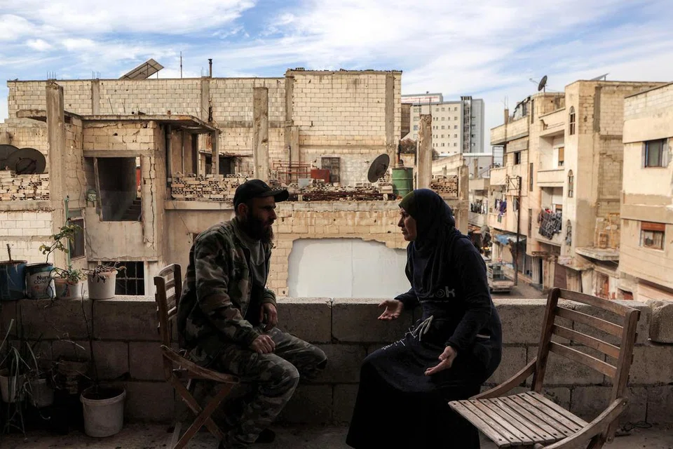 Seorang anggota kumpulan Tentera Nasional Syria yang disokong Turkey duduk bersama ibunya selepas kembali ke rumah mereka di daerah Waer, Homs, pada 16 Disember. Kepulangannya menamatkan tujuh tahun kehidupan sebagai pelarian akibat konflik di Syria.