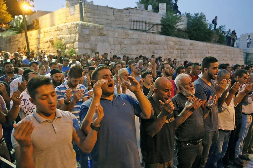 DIBENARKAN MASUK: Penduduk Palestin yang bersolat di luar Masjid Al-Aqsa ini telah dibenarkan memasuki masjid tersebut selepas Israel menarik balik beberapa sekatan yang dikenakan sebelum ini. - Foto AFP