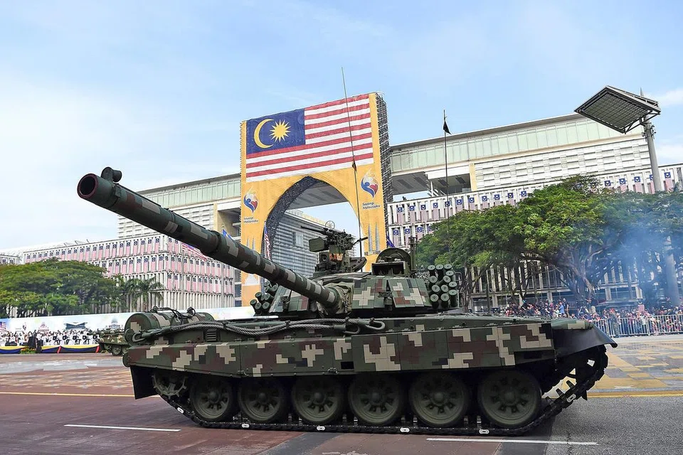 PERTAHANAN NEGARA: Kereta kebal ini antara 251 aset darat milik Polis Diraja Malaysia, Angkatan Tentera Malaysia dan agensi lain yang diketengahkan dalam perbarisan semalam. - Foto AFP