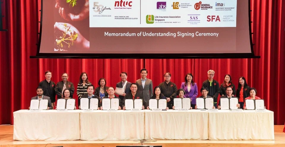 Representatives of NTUC and IBF, along with those of the seven financial associations, at the signing of the memorandum of understanding at the NTUC Centre on Aug 16.