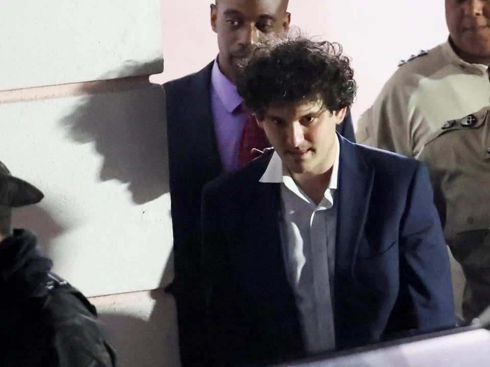 Sam Bankman-Fried, who founded and led FTX until a liquidity crunch forced the cryptocurrency exchange to declare bankruptcy, is escorted out of the Magistrate Court building after his arrest, in Nassau, Bahamas, on Dec 13. 