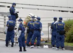 Police officers and firefighters investigate at the site where a man who was protesting a state funeral for former Japanese Prime Minister Shinzo Abe set himself on fire, near Prime Minster Fumio Kishida's official residence in Tokyo, Japan Sept 21, 2022.